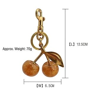 Willow and Wish Boutique glitter resin cherry bag charm with rich gold cherries and bronze gold hardware